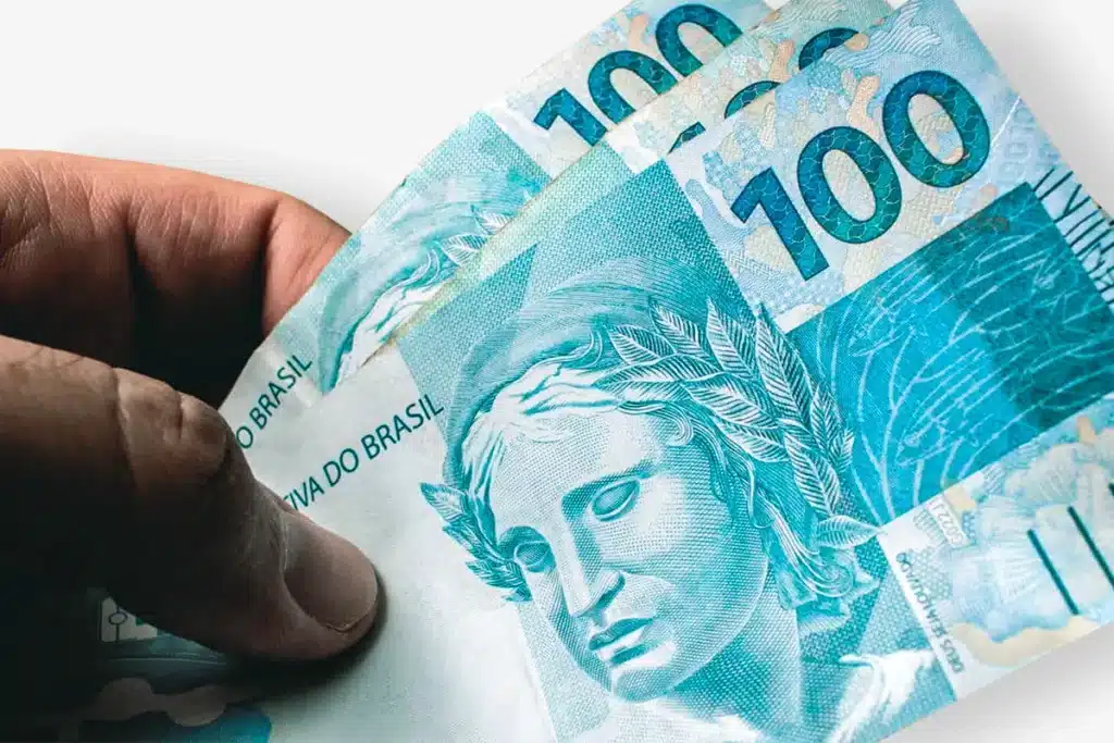 Dívidas dos idosos Notas de 100 reais do Brasil, ilustrando uma transação financeira, usadas para explicar as dívidas cobertas pela lei.