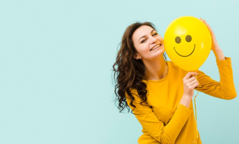 Imagem de mulher sorrindo com um balão amarelo