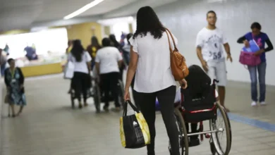 Imagem de uma mulher empurrando uma cadeira de rodas de um beneficiário do BPC