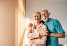 Casal maduro sorrindo e se abraçando em casa, transmitindo felicidade e amor.