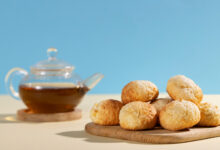 Pãozinhos de tapioca frescos ao lado de uma chaleira de chá, representando a receita fácil e rápida de pãozinho de tapioca.