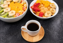 Prato de café da manhã com frutas frescas, cereais e café.