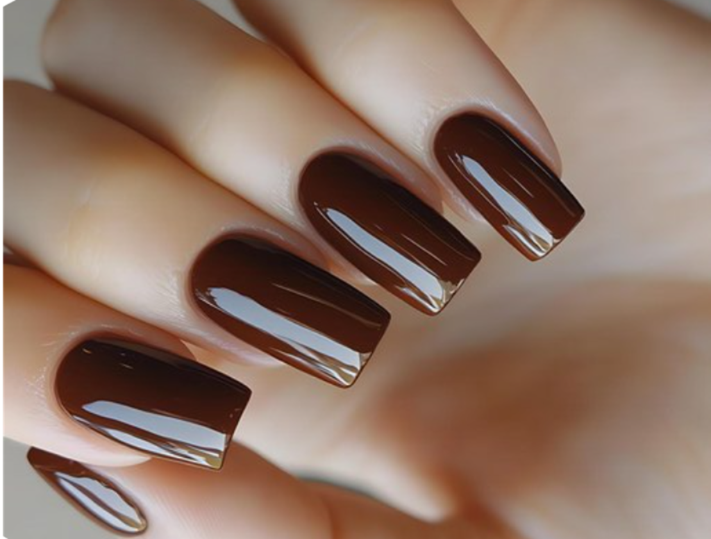 Unhas longas pintadas com esmalte marrom chocolate, destacando elegância e modernidade.