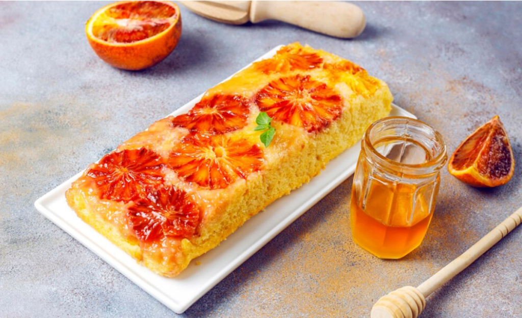 Bolo de laranja coberto com fatias de laranja caramelizada e mel, servindo como uma deliciosa variação de cobertura.