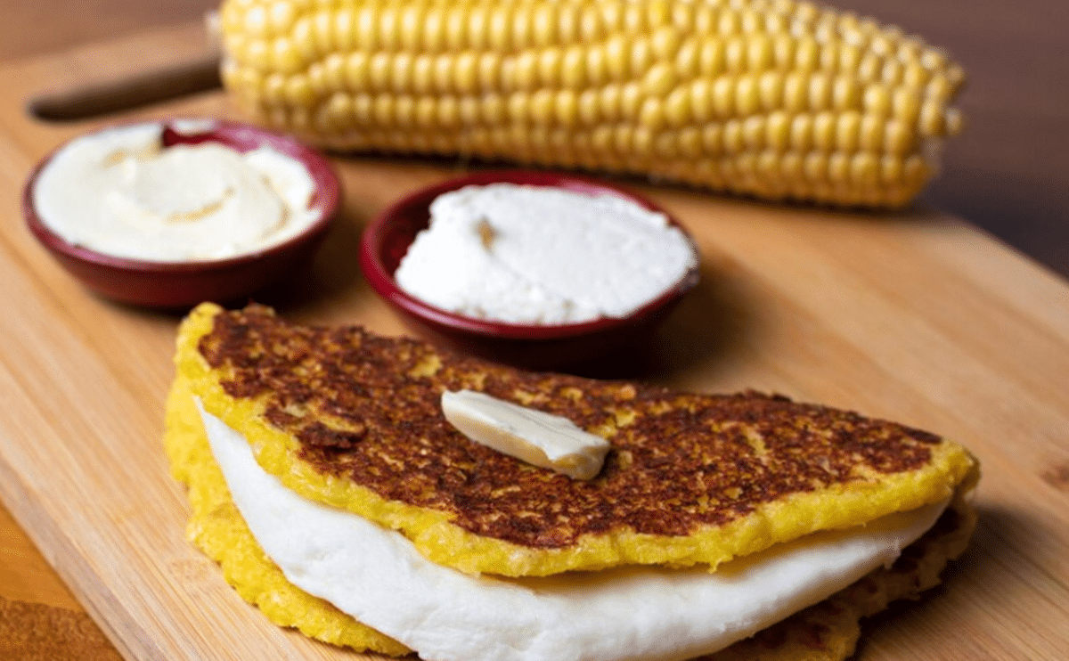 Pãozinho de milho de frigideira servido com manteiga e queijo.
