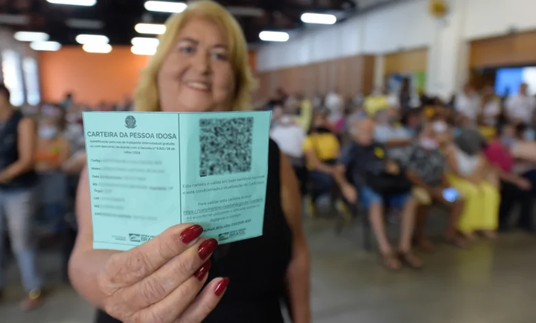 Pessoa idosa segurando a Carteira do Idoso com fundo desfocado