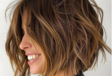 Mulher com corte bob texturizado e luzes douradas, sorrindo e destacando um estilo moderno.