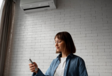 Mulher ajustando a temperatura do ar-condicionado com um controle remoto.