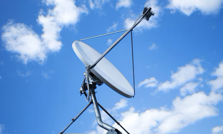 Antena parabólica instalada no telhado contra um céu azul com nuvens.