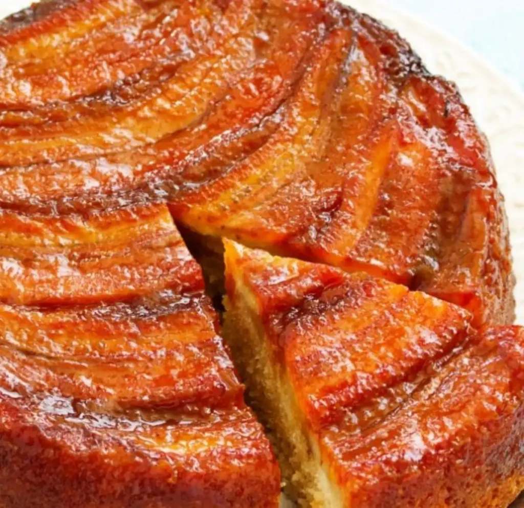 Torta de banana caramelizada com uma fatia cortada, pronta para servir.