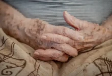 Mãos envelhecidas de um idoso com as unhas bem cuidadas, representando o público-alvo das isenções para maiores de 60 anos.