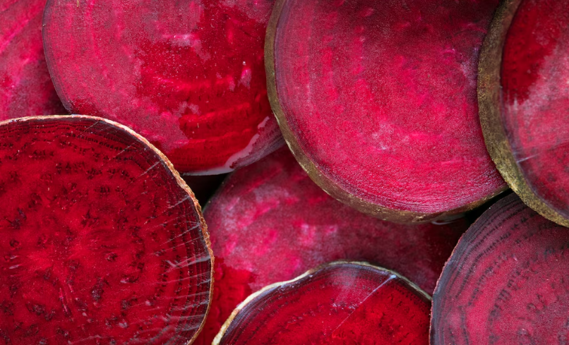 Close-up de fatias de beterraba, destacando sua cor intensa e textura fresca, simbolizando seus benefícios nutricionais.