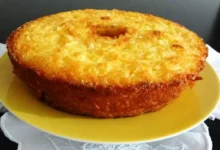 Bolo de mandioca dourado e cremoso servido em um prato amarelo