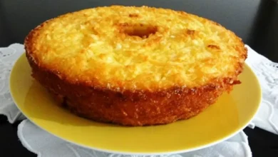 Bolo de mandioca dourado e cremoso servido em um prato amarelo