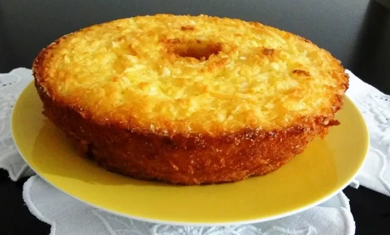 Bolo de mandioca dourado e cremoso servido em um prato amarelo