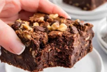 Bolo de chocolate com pedaços de nozes e cobertura de ganache, uma deliciosa variação de bolo de chocolate.