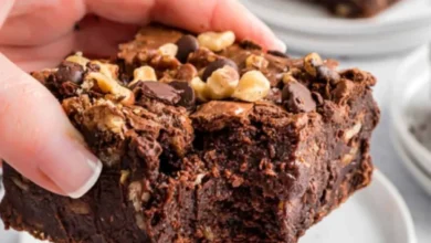 Bolo de chocolate com pedaços de nozes e cobertura de ganache, uma deliciosa variação de bolo de chocolate.