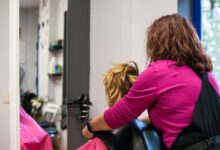 Profissional de cabelo cortando o cabelo de uma cliente em um salão de beleza.