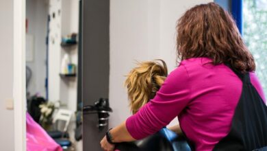 Profissional de cabelo cortando o cabelo de uma cliente em um salão de beleza.