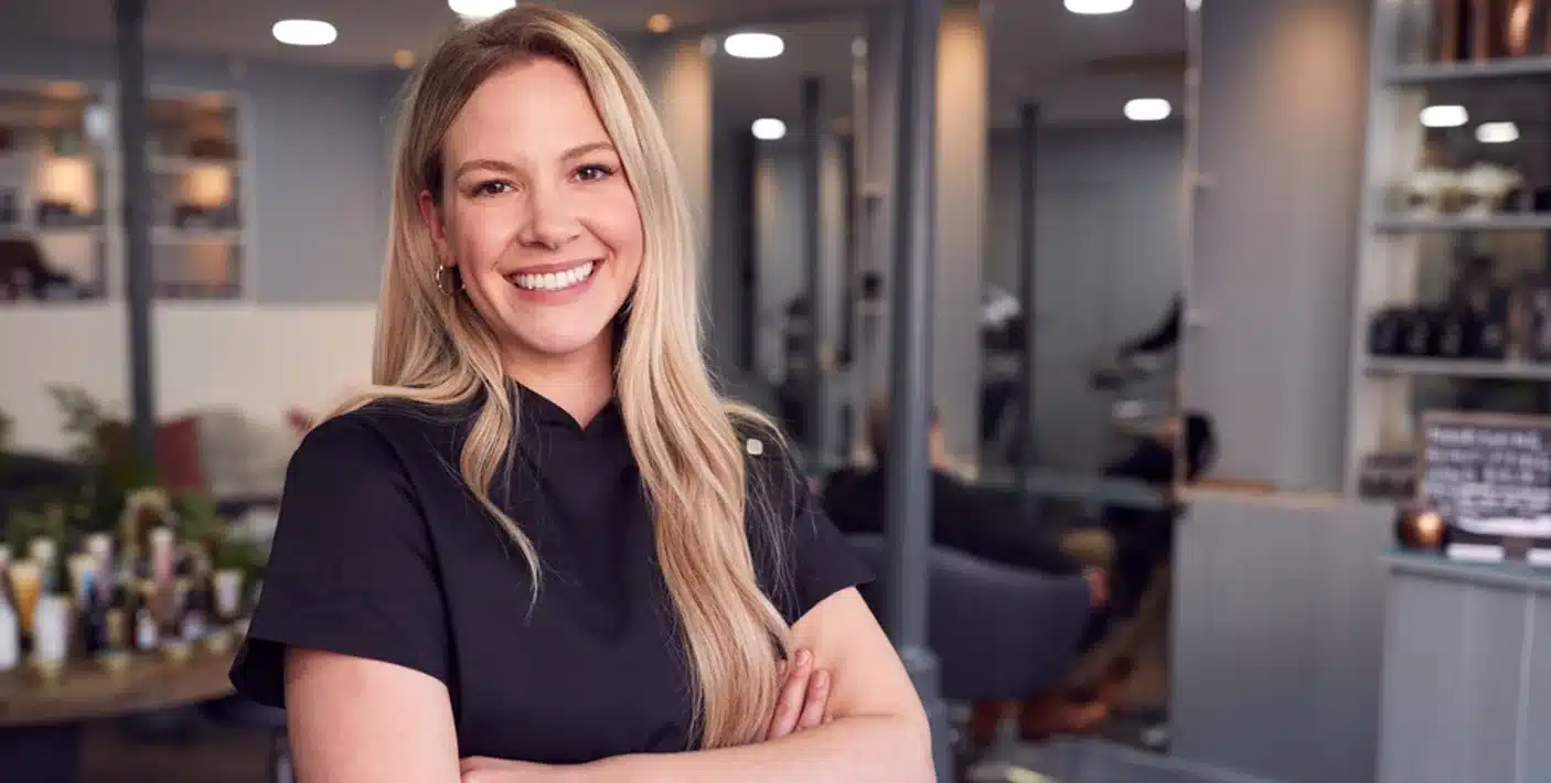 Profissional de salão de cabeleireiro sorrindo.