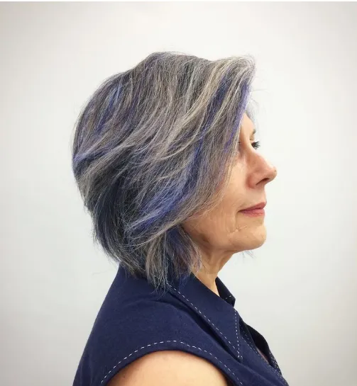 Mulher com cabelo cinza e mechas roxas, trazendo um visual moderno e colorido para o Carnaval.