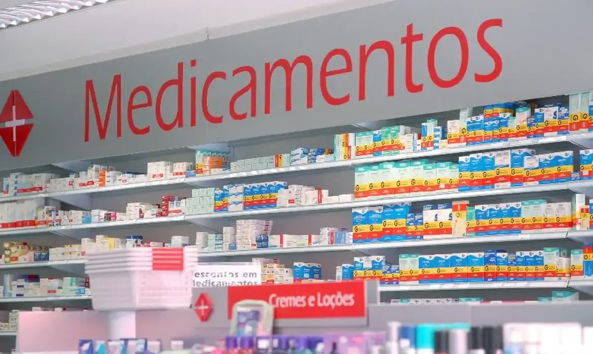 Prateleiras de farmácia repletas de medicamentos genéricos e de marca.