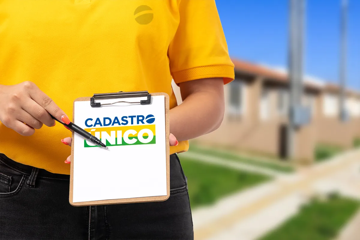 Pessoa segurando prancheta com logo do CadÚnico em um fundo residencial.