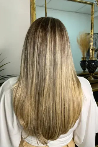 Cabelo com camadas invisíveis, destacando as luzes e o corte reto.