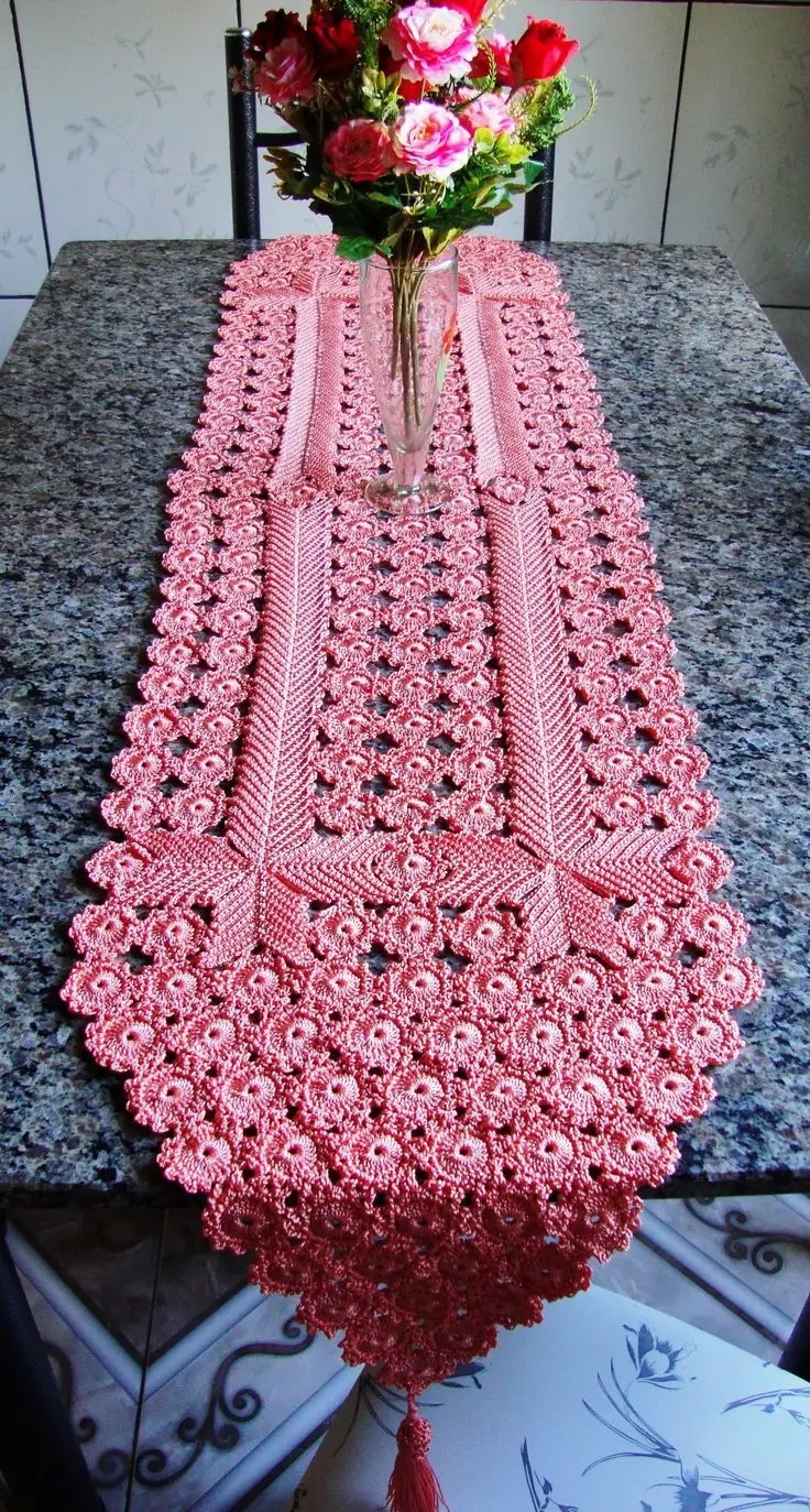 Caminho de mesa de crochê rosa com design sofisticado sobre mesa de mármore