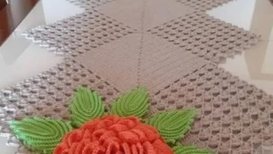 Caminho de mesa em crochê com flores e folhas em alto relevo.