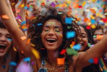 Mulher sorrindo em meio a confetes coloridos, com maquiagem brilhante para o Carnaval.