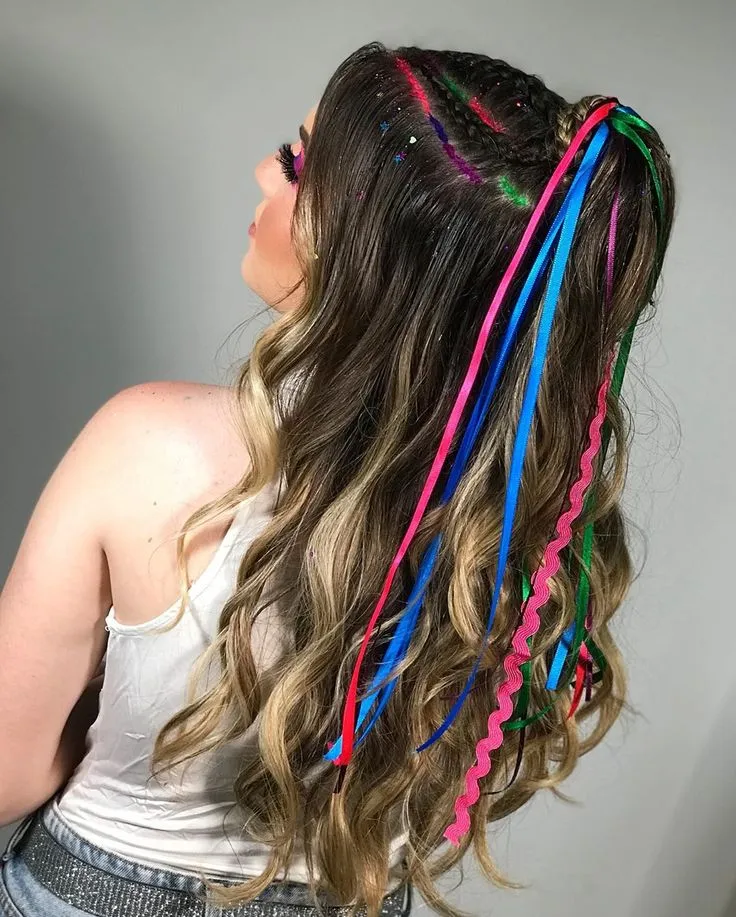 Penteado de Carnaval com tranças, glitter e fitas coloridas para um visual vibrante e festivo.