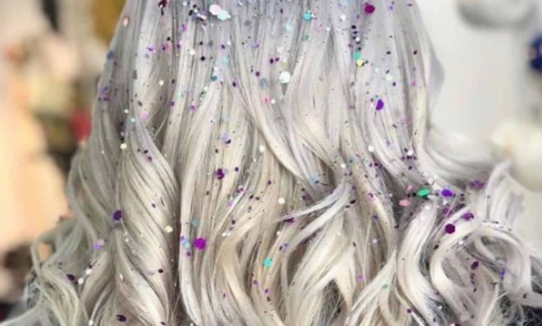 Cabelo loiro ondulado com brilhos coloridos, ideal para um penteado ousado no Carnaval.