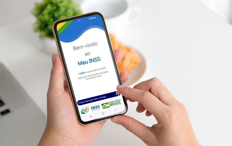 Pessoa acessando o aplicativo Meu INSS no celular