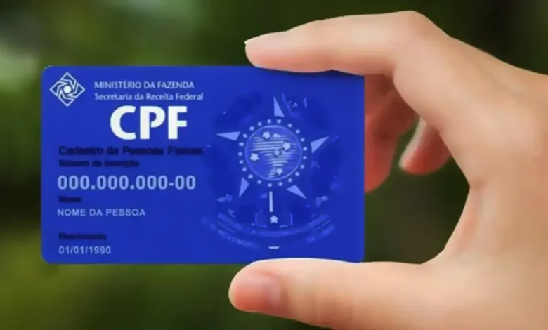 Cartão de CPF segurado por uma mão, representando a consulta do saldo do Bolsa Família pelo documento.