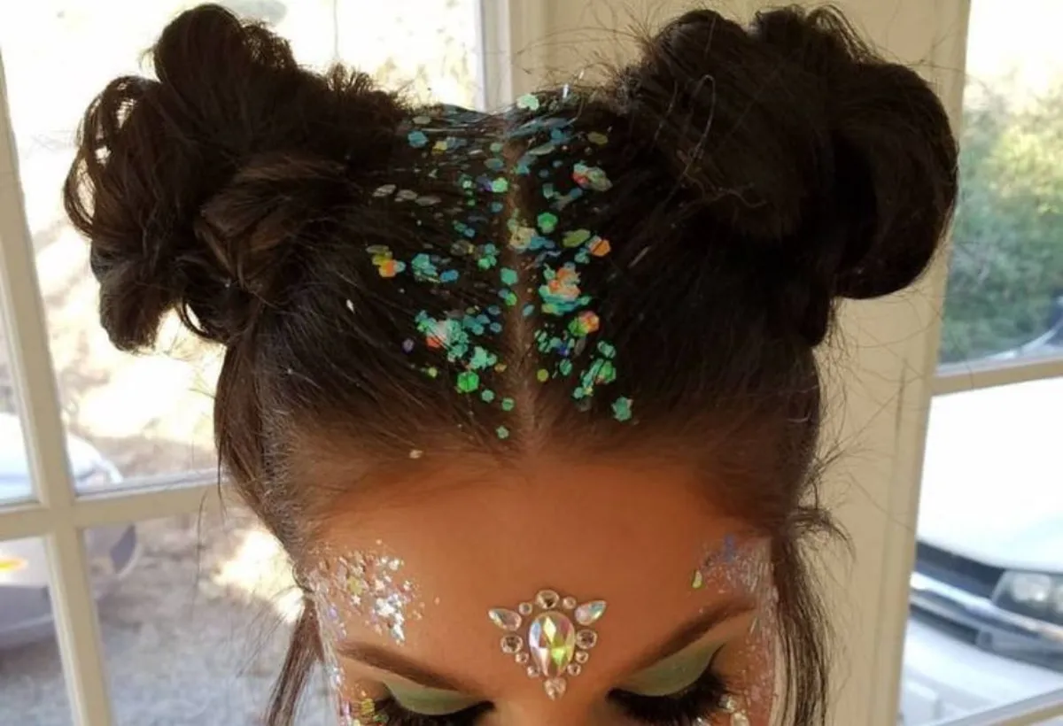 Penteado coque duplo com glitter para um visual criativo e festivo no Carnaval.