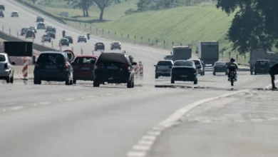 Carros circulando em estrada com obras em andamento.