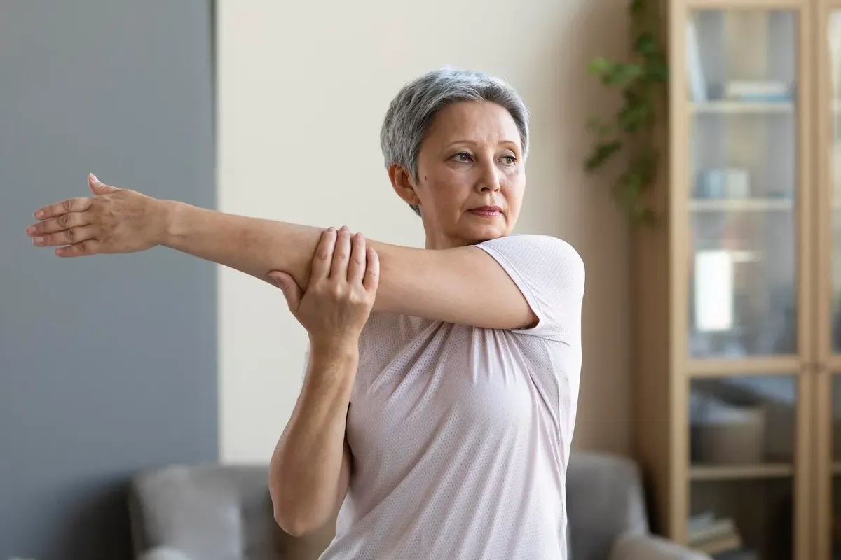  Mulher idosa realizando exercício de alongamento, uma das estratégias eficazes para prevenir a osteoporose.