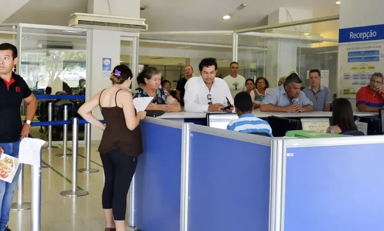 Fila de espera no INSS com pessoas aguardando atendimento.