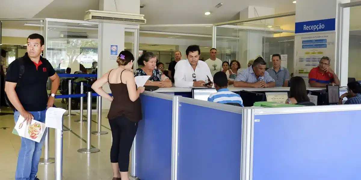 Fila de espera no INSS com pessoas aguardando atendimento.