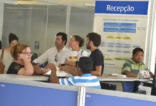 Fila de atendimento no INSS durante a greve dos peritos médicos, com pessoas aguardando para receber benefícios.