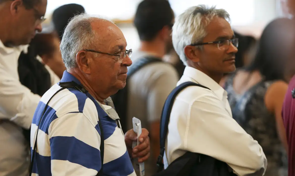 Aposentados aguardando na fila para atendimento do INSS.