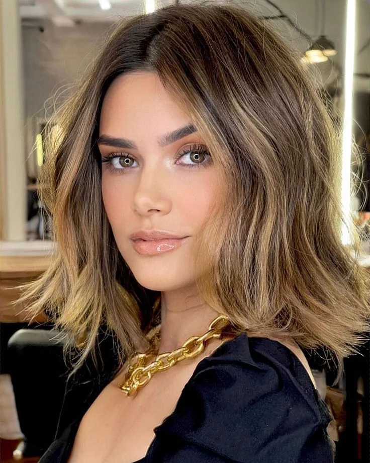 Mulher com corte de cabelo Long Bob elegante, usando um colar dourado