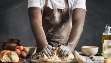 Homem amassando massa de pão na cozinha.