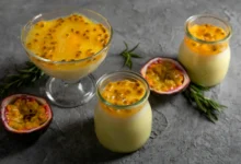 Mousse de maracujá cremoso servido em taças e potes de vidro, decorado com polpa da fruta