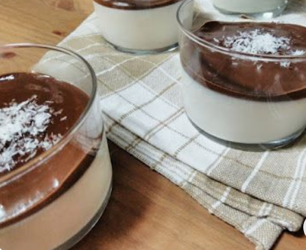 Mousse de coco cremoso com cobertura de chocolate servido em taças de vidro.