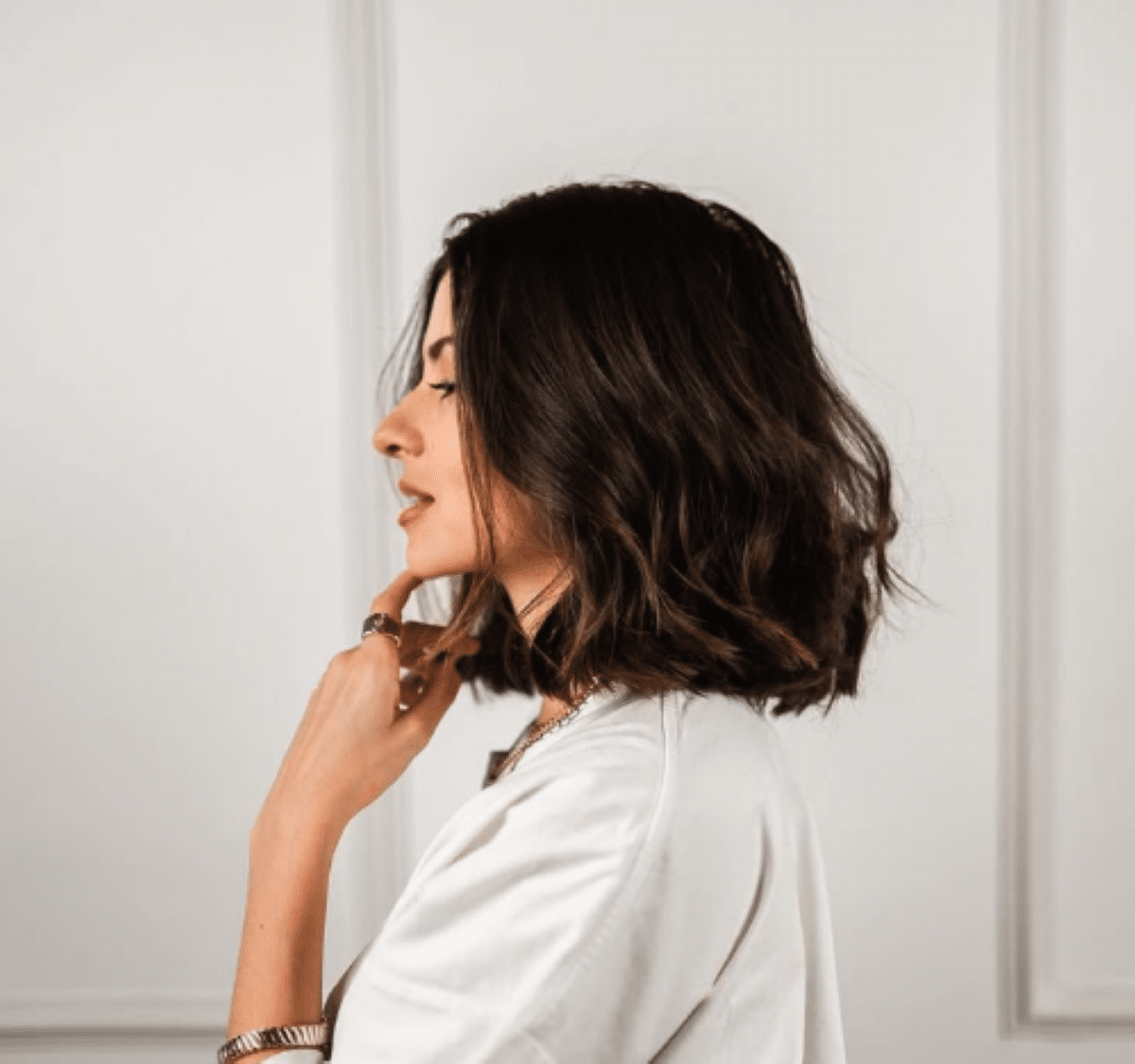 Mulher com cabelo curto e ondulado, penteado com um visual elegante e moderno.