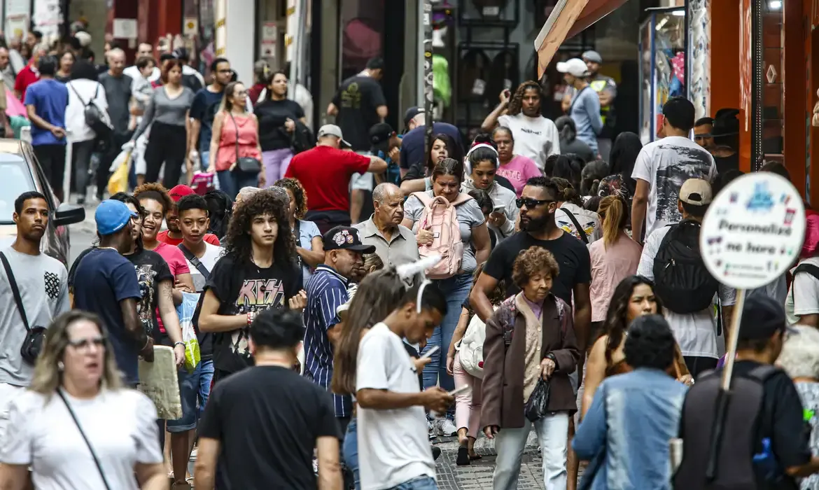 Pessoas em uma rua movimentada, representando a situação de inadimplência, mas não significando que a dívida foi perdoada.