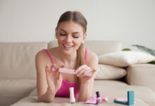 Mulher cuidando das unhas em casa com kit de esmaltação.