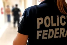 Agente da Polícia Federal em corredor durante operação contra fraudes no INSS.